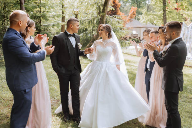 full-length portrait of the newlyweds and their friends at the wedding. The bride and groom with bridesmaids and friends of the groom are having fun and rejoicing at the wedding.